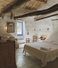 a bedroom with a bed, dresser and mirror in it's center area next to a sink