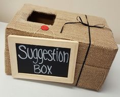 a wooden box with a chalkboard attached to it that says suggestion box