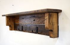 a wooden shelf with two hooks on it