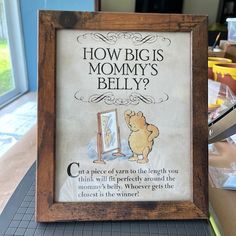 a wooden frame with a sign on it that says how big is mommy's belly?