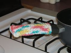 a crocheted dog bone is sitting on the stove burner next to a pot holder