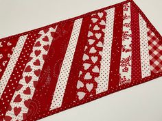 a red and white table runner with hearts on it