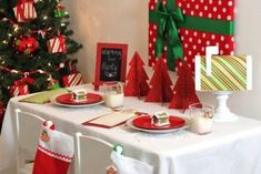 a table set for christmas dinner with stockings on it