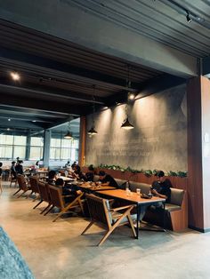 people sitting at tables in a restaurant with large chalkboard on the wall behind them