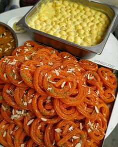 an assortment of food items displayed on a table with other foods in bowls and pans