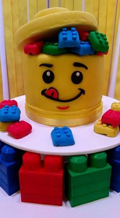 a yellow lego hat sitting on top of a white table next to colorful blocks and toys