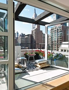 an apartment balcony with large windows overlooking the city