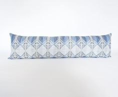 a blue and white pillow on a white background