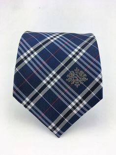 "For the man who loves plaid, Ed's Neckties offers this 100% silk mens plain necktie. Features a navy blue background with blue, gray and red plaid pattern. Available as a extra long tie. Handmade from 100% silk, this special collection features a .75\" Eds Neckties logo at the bottom right front corner of every tie and a larger logo located on the tipping (Back of the tie). The label features the collection name (Nathaniel Alexandria) Named after my son Nathaniel and my daughter Alexandria. Exp Classic Plaid Suit And Tie Accessories For Office, Navy Suit And Tie Accessories For Business, Classic Neckwear For Gifts, Classic Plaid Business Suit And Tie Accessories, Plaid Suit And Tie Accessories For Business, Classic Plaid Ties For Formal Occasions, Classic Plaid Standard Tie, Fitted Plaid Ties, Make A Tie