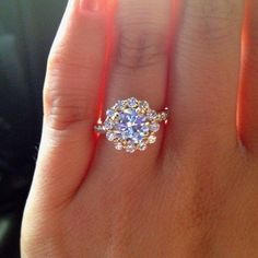 a woman's hand with a ring on it and a diamond in the middle