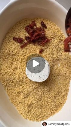 a bowl filled with rice and other food on top of a table next to a spoon