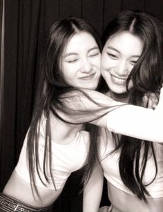 two young women are hugging each other in black and white