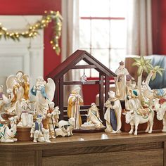 a nativity scene with figurines on a table in front of a christmas tree