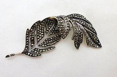 "A Beautiful Vintage European Art Deco Era Fine Sterling Silver Marcasite Leaf Form Brooch Pin. So elegant and beautiful. Wear it on a lapel, dress or even in your hair a a barrette. It is a nice large sparkly statement piece. Looks especially brilliant on black with the pierced areas showing thru. Uniquely and artfully designed with the end of the leaf being folded over for a three dimensional form. Looks much prettier in person than the photos depict.  The back of the pin is marked .925 for Sterling along with two other tiny marks. I believe one is a country mark and the other a date or maker. The brooch measures 3\" long by 1\" wide. The brooch is in very good vintage condition. Beautiful patina. All marcasites intact and appear to be original. Clasp is nice and snug. Pin stem has a sli Elegant Leaf-shaped Brooches For Gifts, Lapel Dress, Artfully Designed, Vintage European, Sterling Silver Marcasite, European Art, Art Deco Era, European Vintage, Silver Leaf