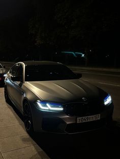 two cars parked next to each other on the side of a city street at night