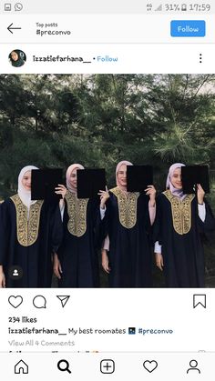 four women dressed in black and gold are holding up their heads with the same image on them