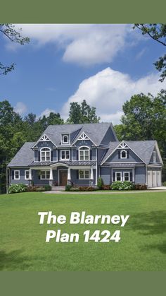 a large blue house sitting in the middle of a lush green field with lots of trees