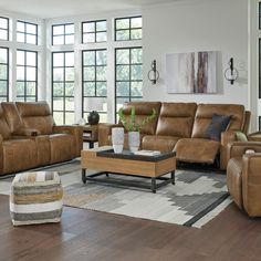 a living room filled with lots of furniture and large windows in the wall behind it