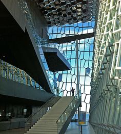 two people are standing at the top of stairs in front of a building with glass windows