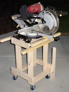 a table sawing machine sitting on top of a wooden cart