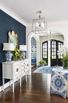 a living room with blue and white decor on the walls, wood floors and an arched doorway