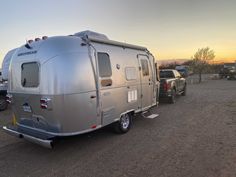 an rv is parked in the parking lot with other vehicles behind it at sunset or dawn