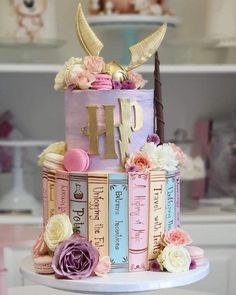 a multi layer cake decorated with books and flowers