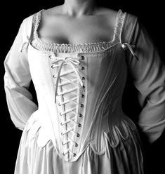 "This 18th century corset is rigidly boned with closely spaced 1/4\" steel bones and is cut to enhance and lift the bust, and shape the waist. The additional lacing up the center front allows for increased adjustment. The waist tabs, cut in one with the corset, curve and smooth over the hips. The over the shoulder straps adjust with a front tie and are basted in at the back. The straps are easily removable. Strapless stays are one of the signature looks of this period. Features include: Ø Side s Corset Stays, 18th Century Stays, 18th Century Dress, Plus Size Corset, Period Costumes, Signature Look, Marie Antoinette, Historical Fashion, Corsets