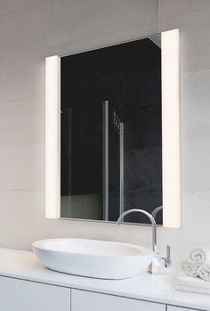 a bathroom with a sink, mirror and towel on the counter in front of it