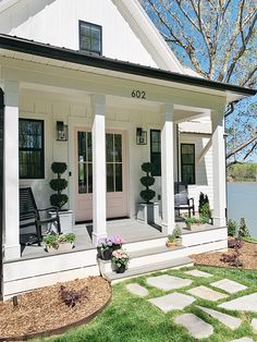 a white house with black shutters on the front porch