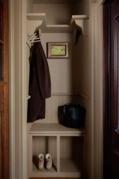 a coat and shoes are hanging on the shelf in this entryway, which also has an open door