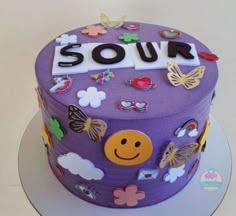 there is a purple cake with butterflies and flowers on the top that says sour