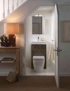 a white toilet sitting in a bathroom next to a wooden table with a basket on it