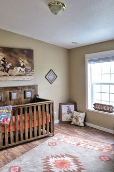 a baby's room with a wooden crib and pictures on the wall