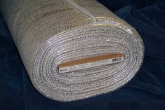 a roll of silver colored fabric on top of a blue cloth covered in sequins