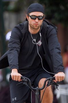 a man riding on the back of a bike wearing headphones and earbuds