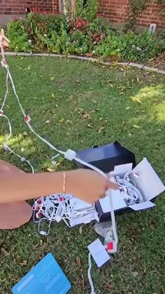 a woman laying on the ground with her arm wrapped around an electric device and wires