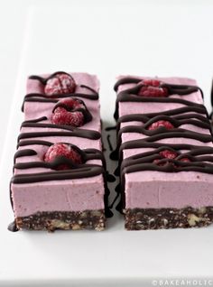 three pieces of dessert on a plate with chocolate and raspberries