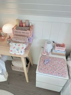 a sewing machine sitting on top of a wooden table next to a white dresser and chair