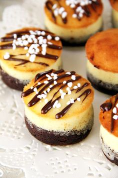 mini cheesecakes with chocolate drizzle and white sprinkles on top