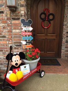 a mickey mouse wagon with flowers in front of a door and sign that says welcome to disney world