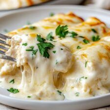 a white plate topped with lasagna covered in cheese