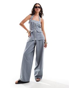 Shop our stylish grey halter utility twill jumpsuit, perfect for a chic and functional wardrobe update. Featuring a flattering silhouette and versatile design, this jumpsuit combines comfort and fashion effortlessly. Ideal for casual outings or dressing up with accessories!