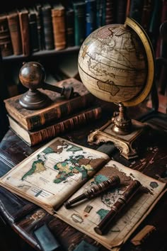 an old world globe, books and pen on a table