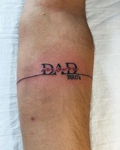 a man's arm with the word dad on it and an arrow in the middle