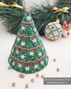 a christmas tree beaded ornament next to ornaments