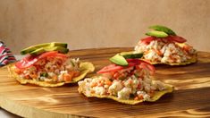 three appetizers are sitting on top of a cutting board with avocado slices