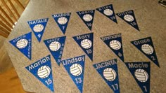 volleyball pennants with names and numbers are displayed on a granite floor in front of a staircase