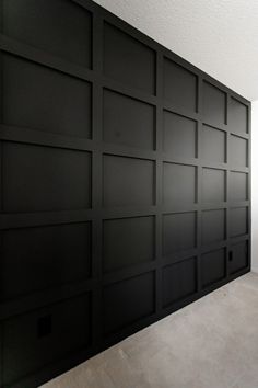 an empty room with black paneling on the wall