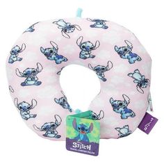 a pink and blue neck pillow with lil the stitcher on it's side